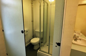 Shared bathroom with toilet, shower and two sinks