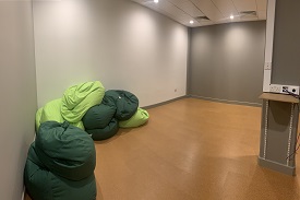An open studio space with lots of beanbags placed alongside two of the walls.
