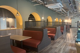 A large seating area with booth seating alongside a central room partician. 