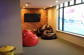 Social space, showing five large beanbags against a wall and a large wall mounted screen