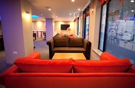 Social space, showing two sofas arranged either side of a coffee table. In the background are beanbags and a wall mounted screen