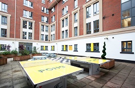 Courtyard view, showing two table tennis tables and circular bench seating