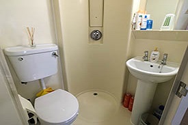 Small bathroom containing a toilet, sink and shower