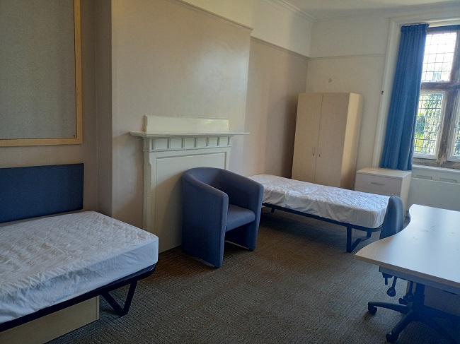 Twin room in the Holmes, one bed in the left of the picture, desk to the right and second bed in the background of the photo. 