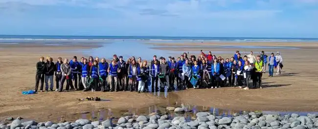 A photo of a team of students on a beach 