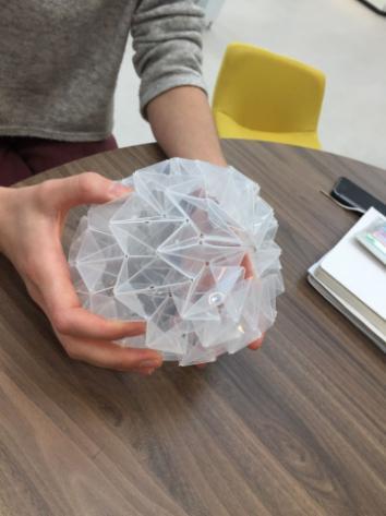 Image of 3d-printed tactile plastic geometric shape being held. 
