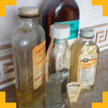 A photograph of various old fashioned remedies in glass bottles such as 'castor oil'