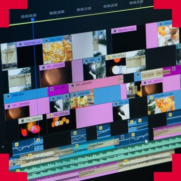 A photograph of video editing software on a screen with many video clips and audio files in different tracks
