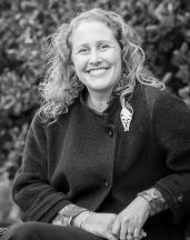 A woman with curly hair sitting outside