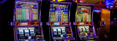 Brightly coloured slot machines in a dark casino