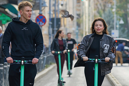 People riding electric scooters in a city