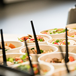 Close up of small pots of food served at an event.