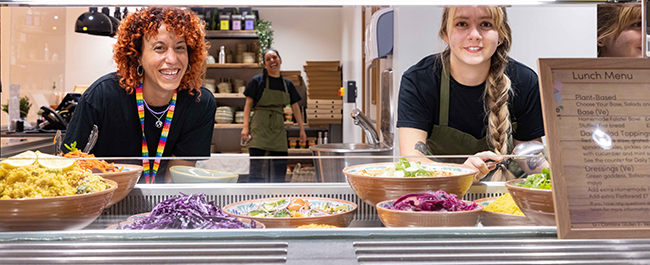 Two members of staff behind the salad counter at the Senate House Marketplace
