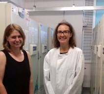 Two people in a freezer room, smiling for the camera.