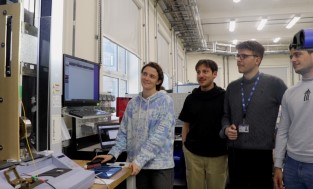 Anna Williams, Gokhan Sancak, Jacopo Lavazza and Asaad Biqai in the composites lab looking at a test machine 