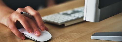 Close up of hand using a computer mouse.