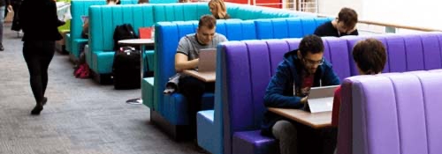 Students sitting in rainbow-coloured booths