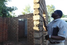 Man inspecting a wall for damage after an earthquake in Malawi