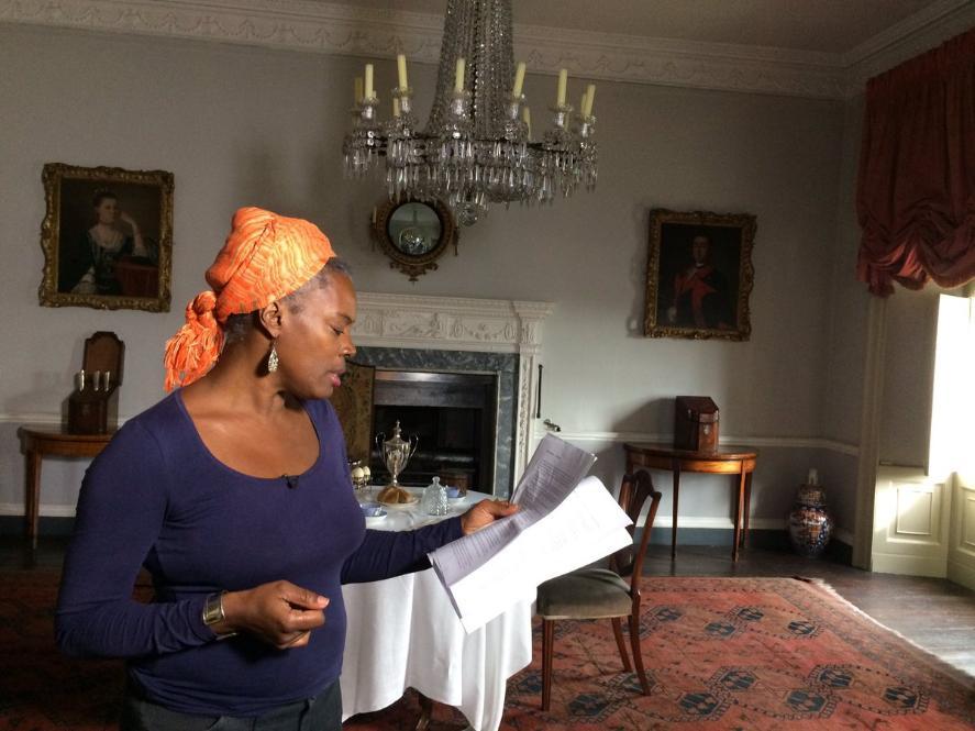 Photo of woman in headscarf reading from papers at the Georgian House