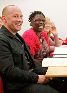Photograph of 3 mature students laughing in a lecture theatre