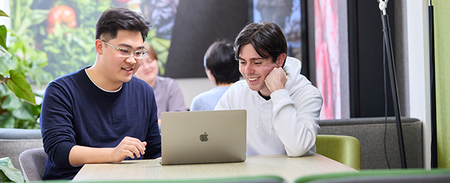 Two students looking at a laptop.