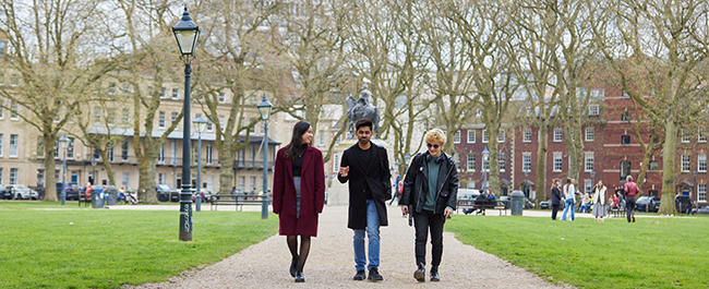 Three students walking through Queen Square.