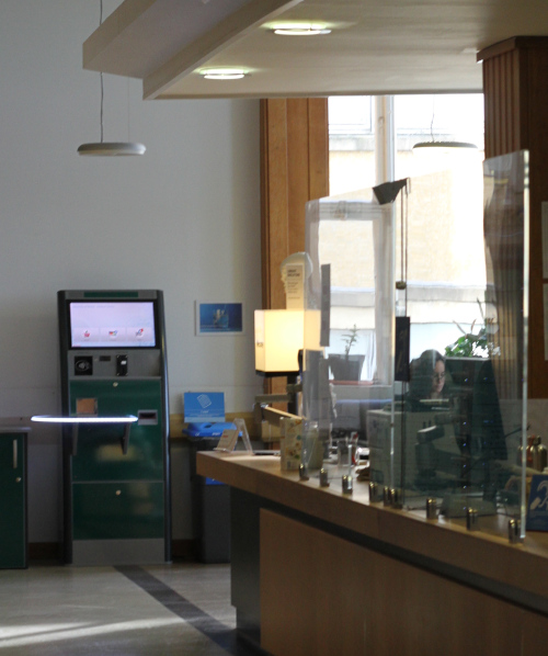 The front desk in the medical library, a machine to check out books is located at the end of the desk.