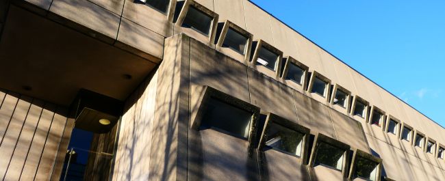 The outside of the Arts and Social Sciences Library - a large rectangular brutalist building with lots of angular windows