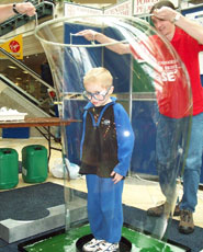 A pupil climbing into a bubble at a 'science of bubbles' demonstration