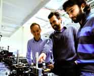 Research physicists Alberto Peruzzo (left), Jeremy O’Brien and Alberto Politi in front of the optical table