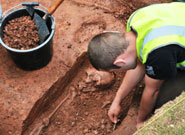 A University of Bristol archaeologist uncovering the skeleton in Dr Jenner's garden