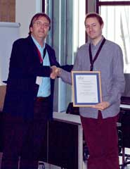 Dr Georg Fuchsbauer (right) receives his award at the 7th International Workshop on Security and Trust Management (STM) in Copenhagen from STM working group chair, Professor Javier Lopez