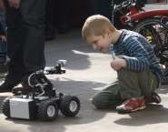 A young pupil is fascinated by one of the robots