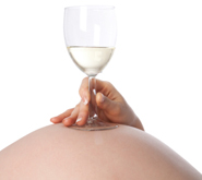 Generic image of a woman lying down holding a glass of wine on her bump