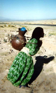 An Ethiopian woman carries water home from the village tap