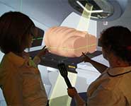 The CURVES suite at Cardiff showing an immersive training session involving two trainee radiographers positioning a virtual patient and enacting a treatment fraction from a virtual LINAC