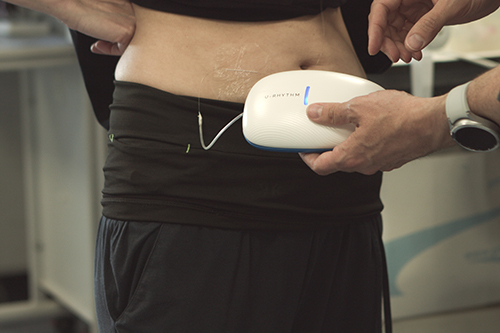 A person wearing the U-RHYTHM device around the hips