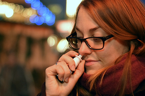 A woman using a nasal spray
