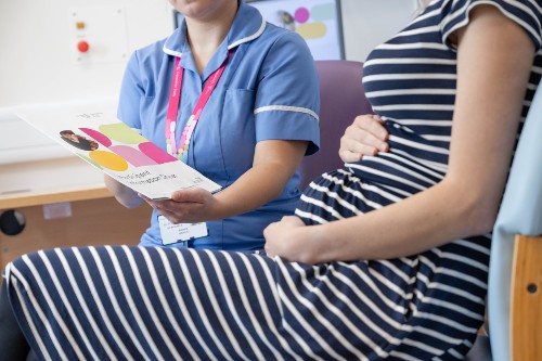 A pregnant woman at St Michael's Hospital in Bristol reading a Generation Study leaflet.