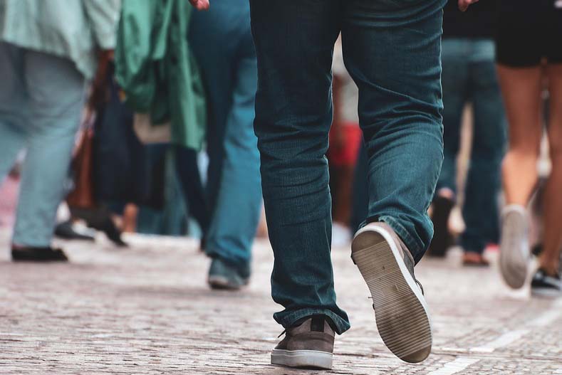 View of people's legs walking along the pavement