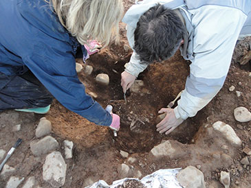 Members of the team carefully excavating around the cremation burial at Trefael