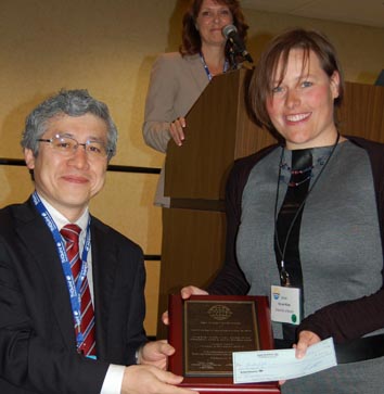 Yohei Otoki, member of the CS ManTech committee and awards chairman, presenting Nicole with her award at the opening ceremony