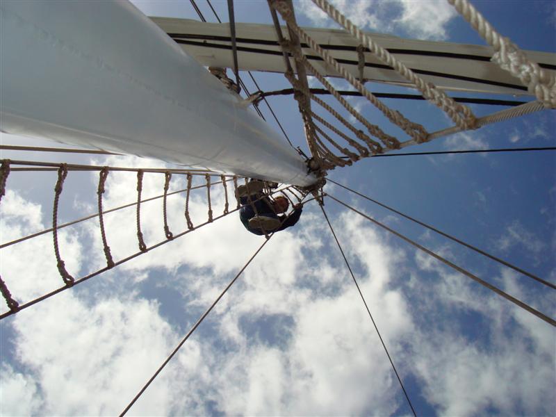 Someone climbing up the rigging of a ship