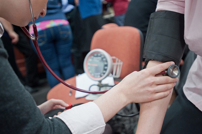 A student takes a person's blood pressure