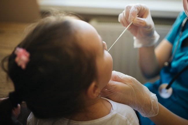 Nurse swabs throat of child