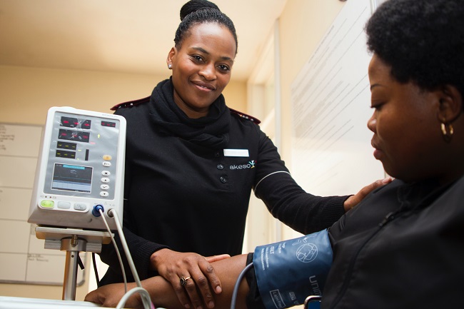 Black female doctor takes blood pressure of Black female patient