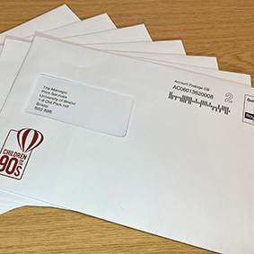Image showing a fanned spread of franked business envelopes size C5 displaying addresses in the window pane and a printed logo in the bottom left corner of the envelope
