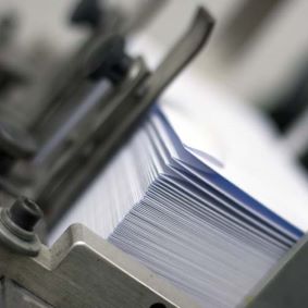 Image showing a stack of envelopes in a machine tray ready to have a letter inserted into them
