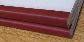 Image showing a couple of soft binds stacked on top of one another with red spines and clear acetate covers