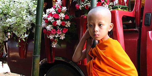 child in saffron robe, at Buddhist festival